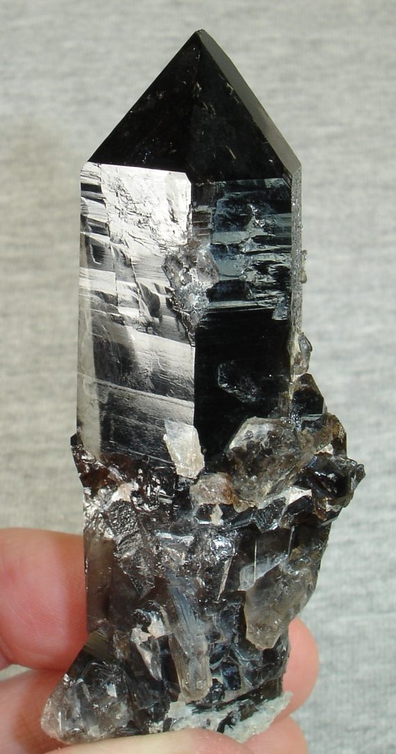 One large smoky quartz crystal with multiple smaller crystals