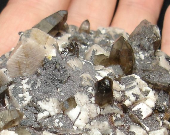 Microcline, smoky quartz, albite, and specular hematite on matrix