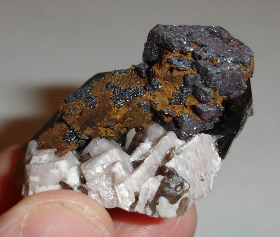 Hematite pseudomorph, smoky quartz, microcline, and albite
