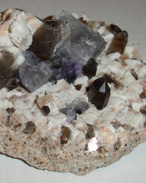 Fluorite, smoky quartz, microcline, and albite on matrix