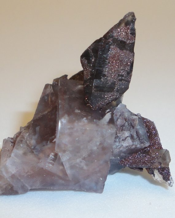A complex specimen of smoky quartz, fluorite, and specular hematite