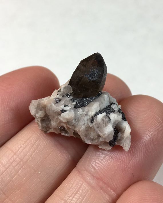 Smoky quartz crystals on a matrix of microcline and albite, with specular hematite